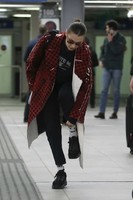 bella-hadid-wears-in-a-red-checkered-pvc-coat-at-milan-airport-in-milan-3-683x1024