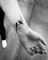 petit-tatouage-homme-branche-d-arbre-et-oiseaux-silhouettes-noirs-des-corbeaux-sur-le-poignet