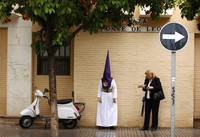 a-penitent-of-la-exaltacion-brotherhood-stands-on-a-pavement-during-holy-week-in-seville