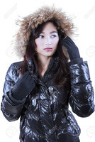 34600141-Pretty-young-woman-in-warm-winter-jacket-with-fur-hood-staring-at-the-copyspace-in-studio-S