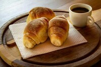 uma-xícara-de-café-com-pães-caseiros-três-em-prancha-corte-e-preto-231543571